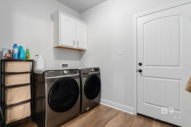 laundry room featuring cabinets, light hardwood / wood-style floors, and washing machine and dryer