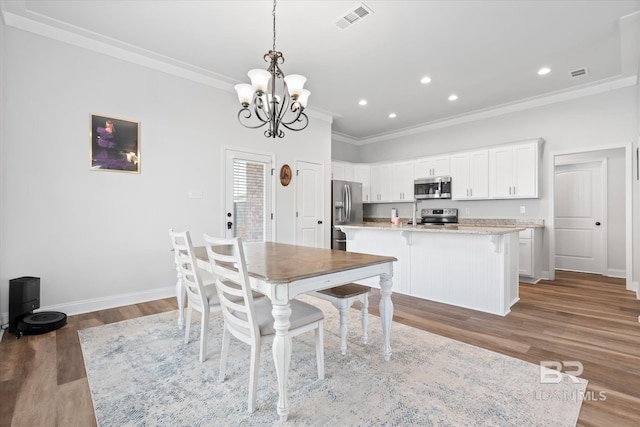 dining area with crown molding, dark hardwood / wood-style floors, and an inviting chandelier