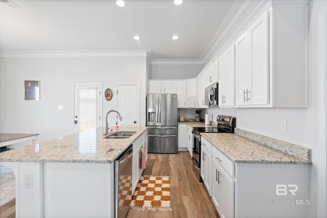 kitchen featuring sink, white cabinetry, stainless steel appliances, light stone counters, and a center island with sink