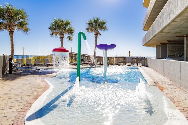 view of swimming pool with pool water feature and a patio area