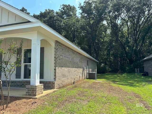 view of side of property with cooling unit and a yard