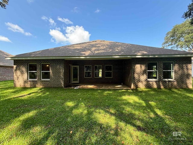 back of property with a yard and a patio area