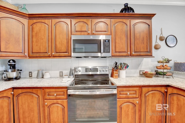 kitchen with backsplash, ornamental molding, light stone countertops, and stainless steel appliances