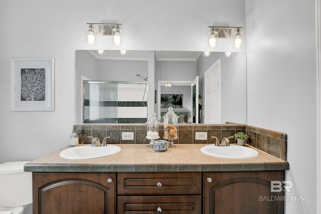 bathroom with backsplash, vanity, toilet, and a shower with shower door