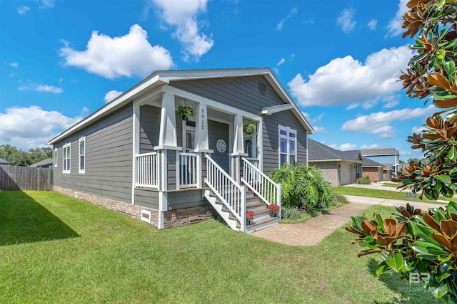 view of front of home featuring a garage, a front yard, and covered porch