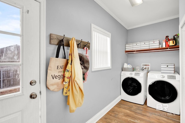 clothes washing area with washer and clothes dryer, crown molding, and hardwood / wood-style floors