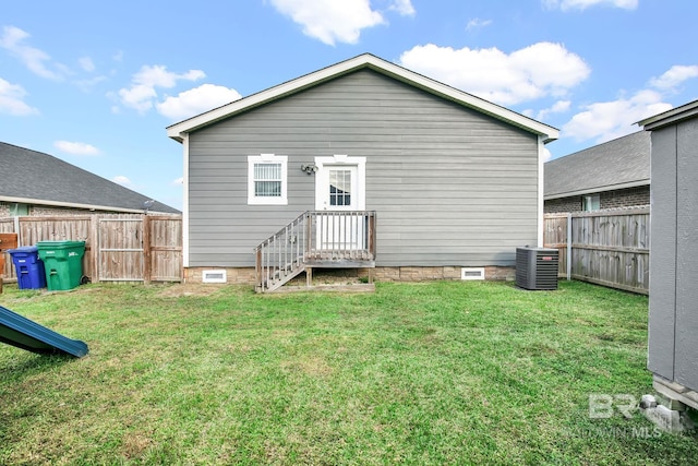 rear view of house featuring a lawn and central air condition unit