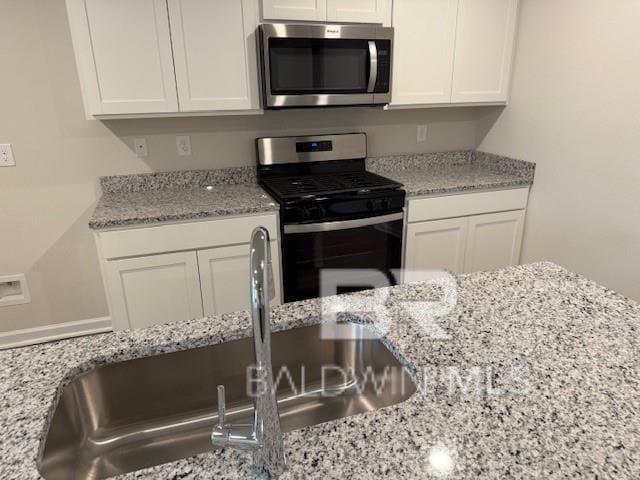 kitchen featuring white cabinetry, sink, and appliances with stainless steel finishes