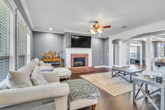 living room featuring visible vents, a fireplace, dark wood finished floors, and decorative columns