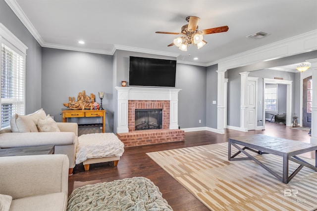 living room featuring a healthy amount of sunlight, dark wood-style floors, baseboards, and visible vents