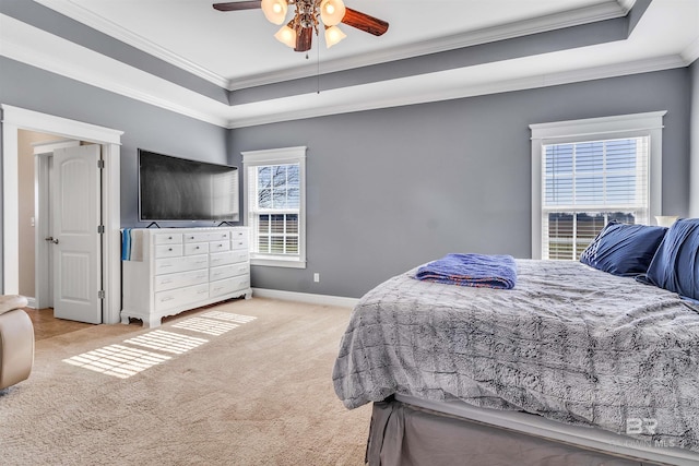 bedroom with light colored carpet, a ceiling fan, baseboards, ornamental molding, and a raised ceiling