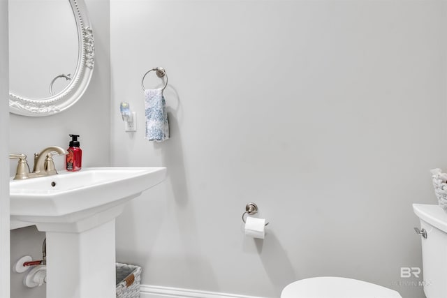 bathroom with toilet and baseboards