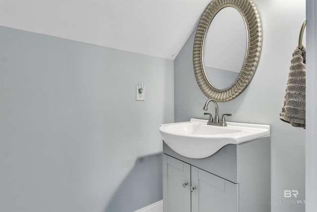 bathroom with vaulted ceiling and vanity