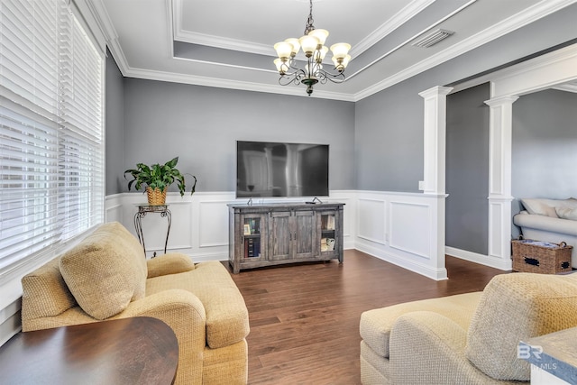 living area with dark wood-type flooring, a tray ceiling, visible vents, and ornate columns