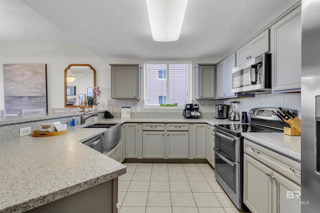 527 Beach Club Trl Unit C110, Gulf Shores, AL 36542 - kitchen featuring appliances with stainless steel finishes, a textured ceiling, light countertops, gray cabinetry, and light tile patterned floors