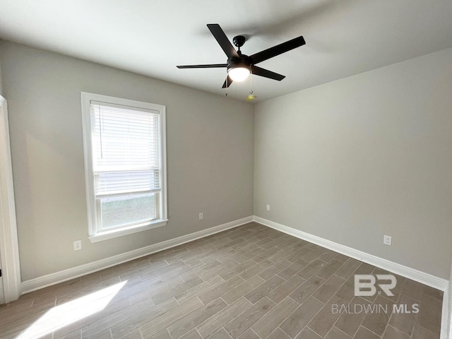 unfurnished room featuring dark wood-style floors, baseboards, and a ceiling fan