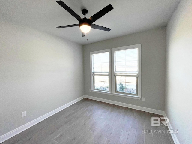 unfurnished room with dark wood finished floors, baseboards, and ceiling fan