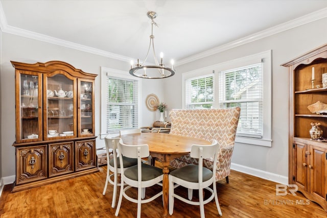 dining room with a chandelier, hardwood / wood-style flooring, and crown molding