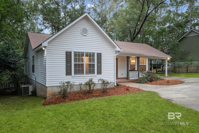 view of front of property with central AC unit, a front yard, and covered porch