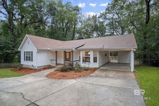 ranch-style home featuring a front lawn, a carport, and a porch