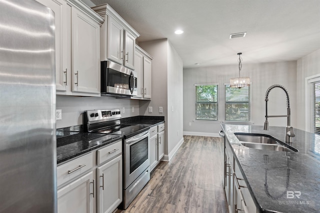 343 Stave Mill Rd, Fairhope, AL 36532 - kitchen with stainless steel appliances, a sink, dark stone counters, visible vents, and wood finished floors