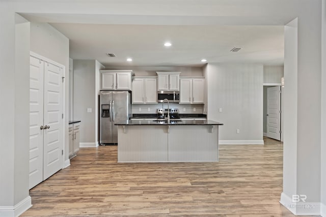 343 Stave Mill Rd, Fairhope, AL 36532 - kitchen with light wood-style floors, stainless steel appliances, a center island with sink, baseboards, and visible vents