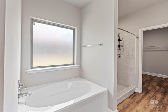 343 Stave Mill Rd, Fairhope, AL 36532 - bathroom with a bath, wood finished floors, a spacious closet, and a stall shower