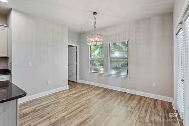 343 Stave Mill Rd, Fairhope, AL 36532 - unfurnished dining area with baseboards, light wood-style floors, and an inviting chandelier