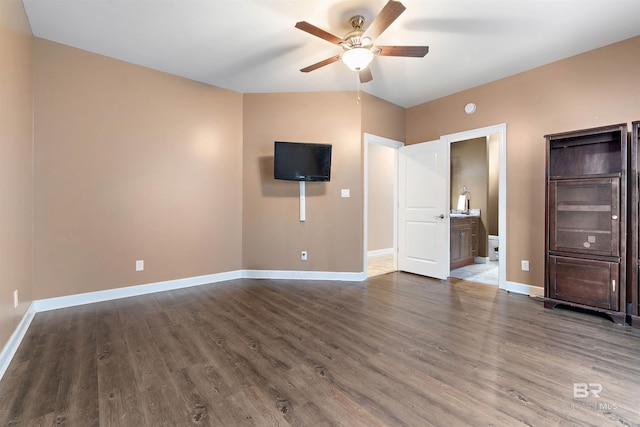 unfurnished bedroom featuring dark hardwood / wood-style floors, ceiling fan, connected bathroom, and vaulted ceiling