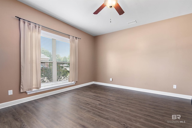 spare room featuring dark hardwood / wood-style flooring and ceiling fan