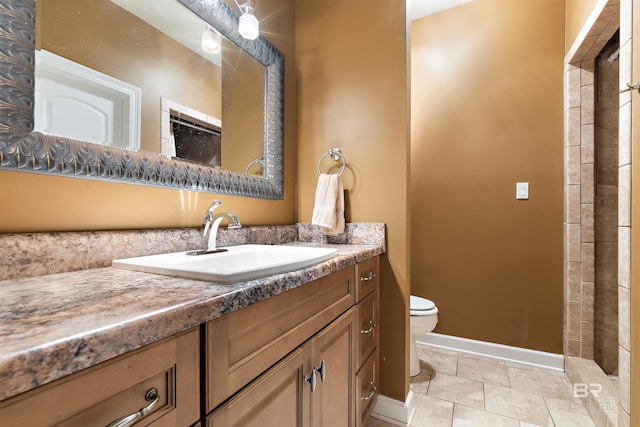 bathroom featuring toilet, tile flooring, and vanity