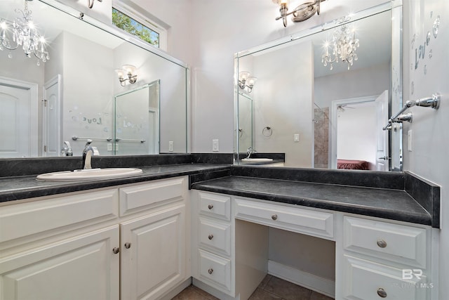 bathroom with double vanity, tile floors, and a notable chandelier