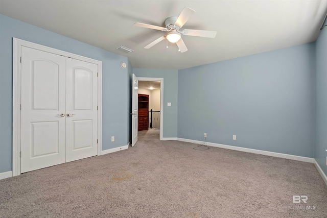 unfurnished bedroom with a closet, ceiling fan, and carpet flooring