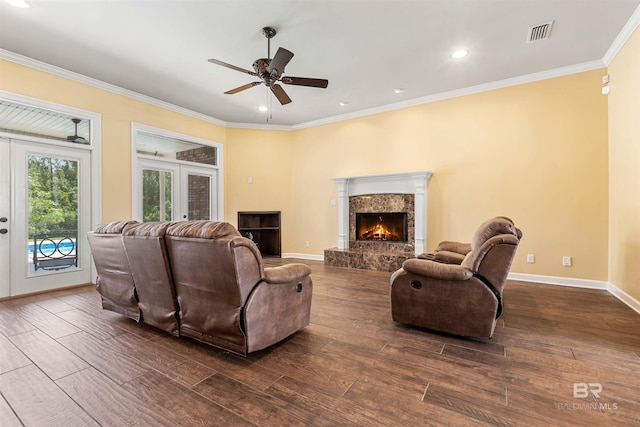 living room with ornamental molding, ceiling fan, a fireplace, and dark hardwood / wood-style floors