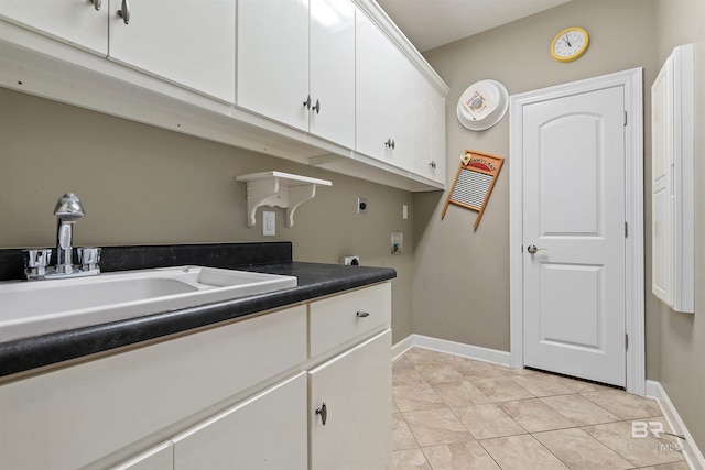 laundry area with hookup for an electric dryer, sink, light tile flooring, and cabinets