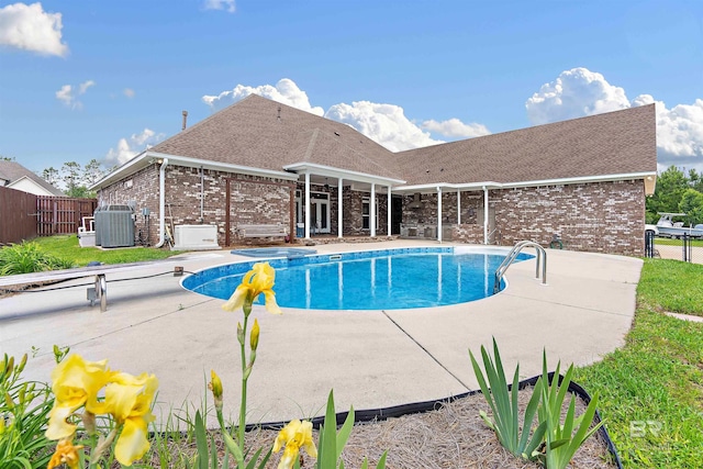 view of swimming pool featuring a patio and a diving board