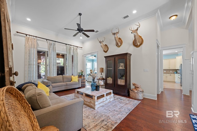living room with visible vents, crown molding, dark wood-style floors, and ceiling fan