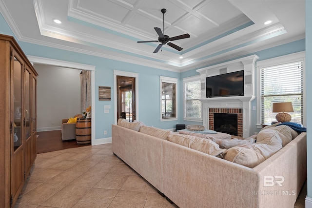 living room featuring a brick fireplace, ceiling fan, a wealth of natural light, and ornamental molding