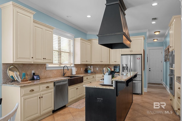 kitchen with light tile patterned flooring, appliances with stainless steel finishes, cream cabinets, and a sink