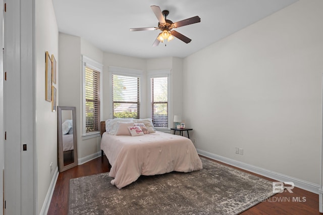 bedroom featuring ceiling fan, baseboards, and wood finished floors