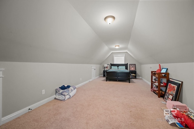 interior space with vaulted ceiling, carpet floors, and baseboards