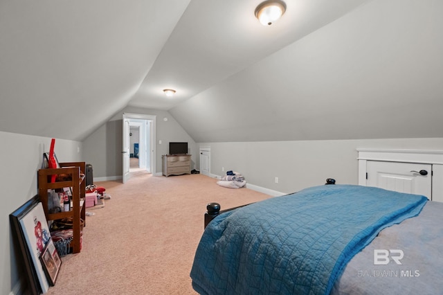 carpeted bedroom featuring lofted ceiling and baseboards