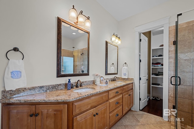 full bath featuring tile patterned flooring, a sink, double vanity, and a stall shower