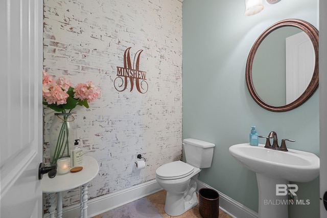 bathroom featuring toilet, baseboards, and tile patterned floors