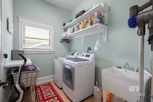 laundry room with a sink, light tile patterned flooring, baseboards, separate washer and dryer, and laundry area