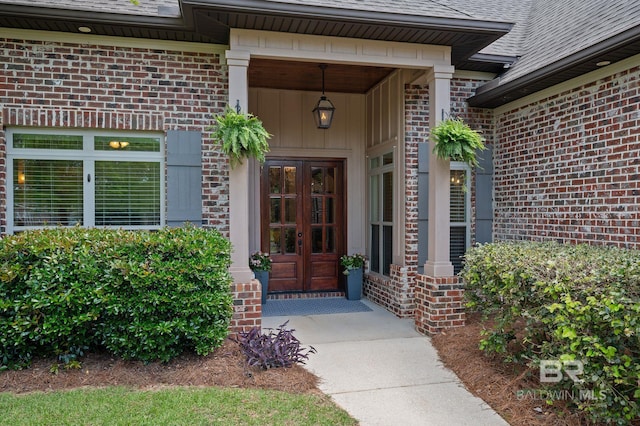 entrance to property with brick siding, roof with shingles, and french doors