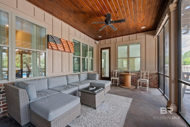 sunroom featuring wood ceiling, outdoor lounge area, wood walls, and ceiling fan