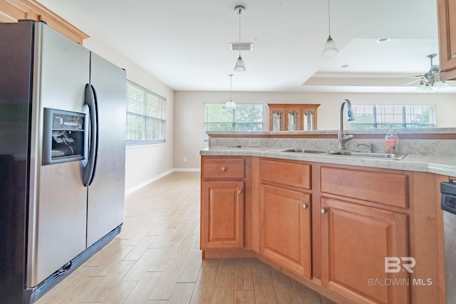 kitchen with stainless steel fridge, a sink, light wood-style floors, light countertops, and visible vents