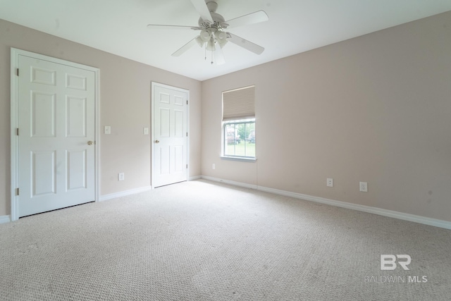 unfurnished bedroom featuring baseboards, ceiling fan, a closet, and light carpet