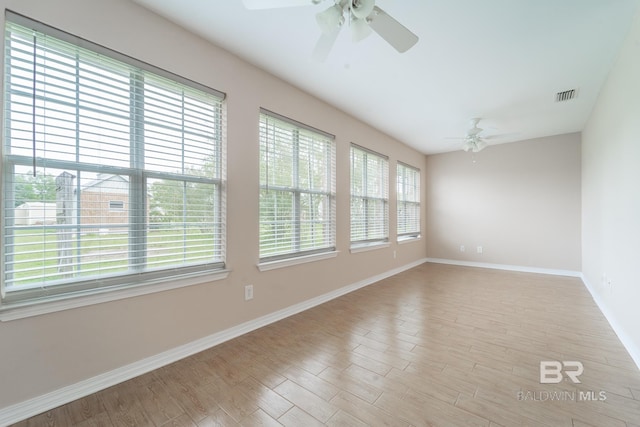 empty room featuring baseboards, a ceiling fan, and visible vents